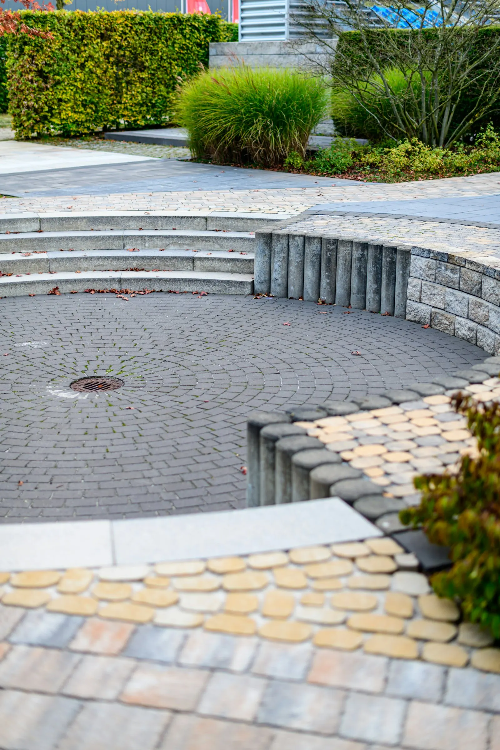 Curved paver patio with built-in seat wall and desert greenery
