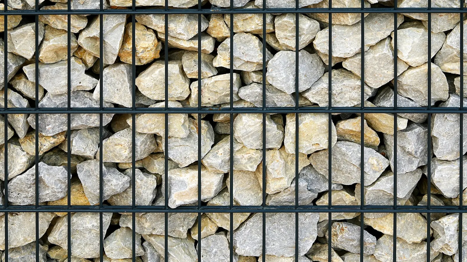 Tan dry-stack stone retaining wall, freshly built